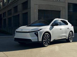 A white 2026 Toyota bZ Electric SUV parked near a building.