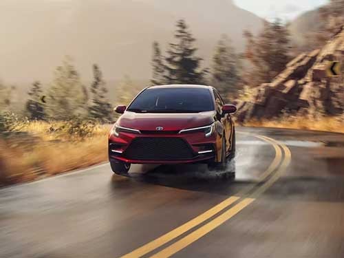 2024 Toyota Corolla Hybrid driving down a road