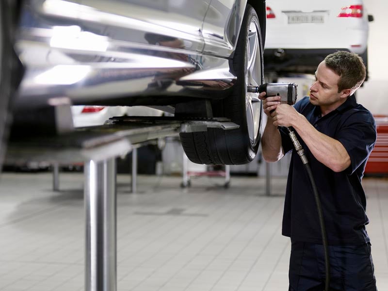 Mechanic working on tire rotation service.